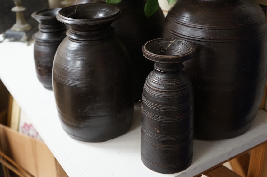 A set of six Nepali turned Himalayan hardwood pots, largest 42cm high. Condition - some breaks and repairs